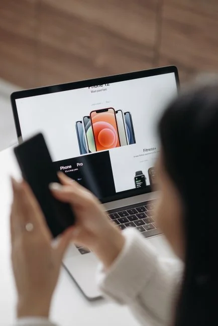 A modern workspace with a smartphone displaying a screen and a computer setup, ideal for business and technology themes.
